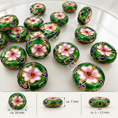 Groene plat-ronde cloisonné kralen van ca. 16 mm met bloemen in wit en roze emaille, gecombineerd met blauwe en rode details en goudkleurig draadwerk.