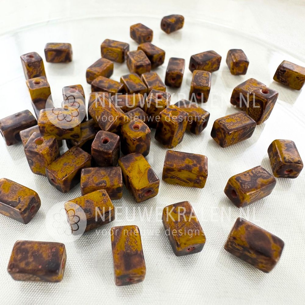 Handgemaakte keramiek kralen groengeel met bruine nuances in rechthoekige buisjesvorm van ca. 9x5 mm.