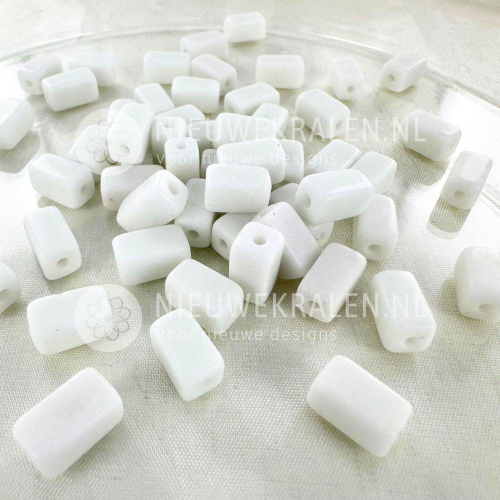 Handgemaakte keramiek kralen wit in rechthoekige buisjesvorm van ca. 9x5 mm.