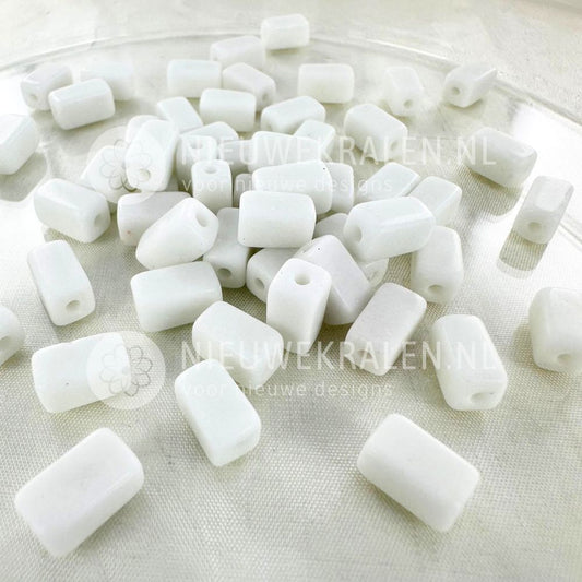 Handgemaakte keramiek kralen wit in rechthoekige buisjesvorm van ca. 9x5 mm.