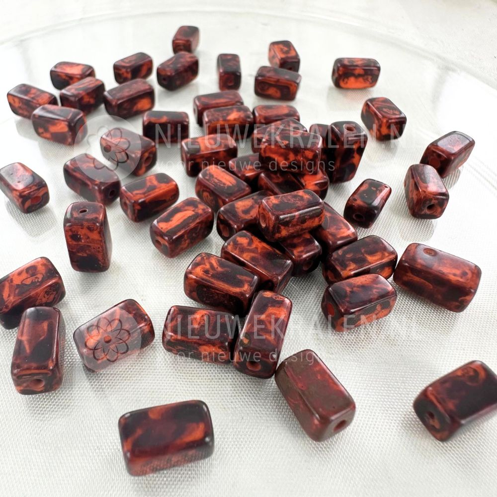 Handgemaakte keramiek kralen donker roodbruin met bruine nuances in rechthoekige buisjesvorm van ca. 9x5 mm.