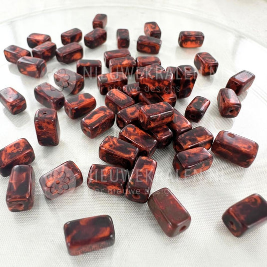 Handgemaakte keramiek kralen donker roodbruin met bruine nuances in rechthoekige buisjesvorm van ca. 9x5 mm.
