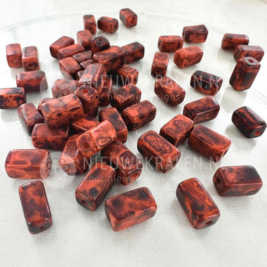 Handgemaakte keramiek kralen roodbruin met bruine nuances in rechthoekige buisjesvorm van ca. 9x5 mm.